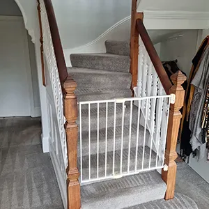 A staircase with a white railing and a gray carpet.
