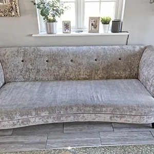 A couch sitting in a living room next to a window.