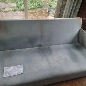 A gray couch sitting on top of a wooden floor.